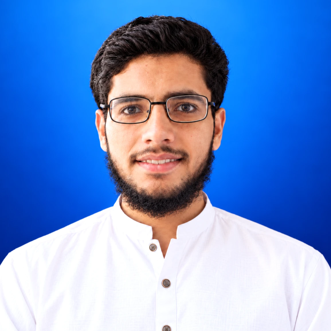 Zia Ur Rehman wearing white shalwar kameez and glasses against a blue background